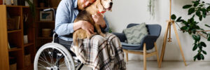 A dog comforting a man in a wheelchair